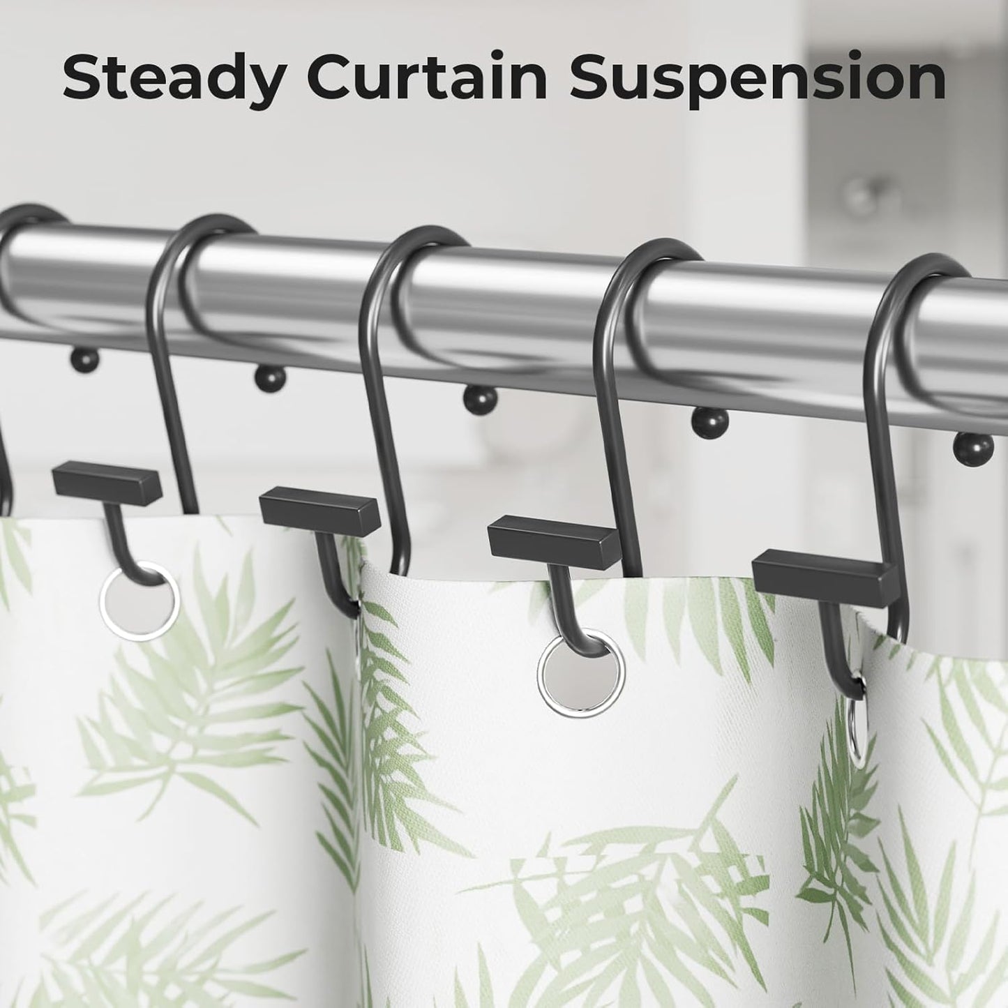 Curtain rod with black hooks holding a green leaf-patterned curtain.